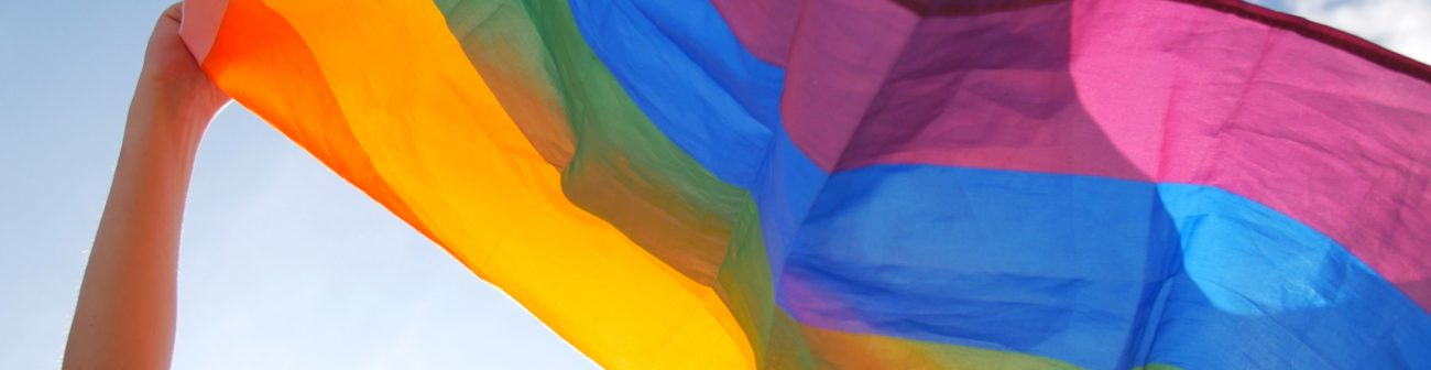 A rainbow pride flag waving in the air.