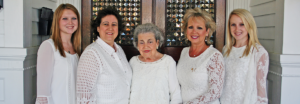 Five Alpha Gamma Delta legacies standing together in white attire.