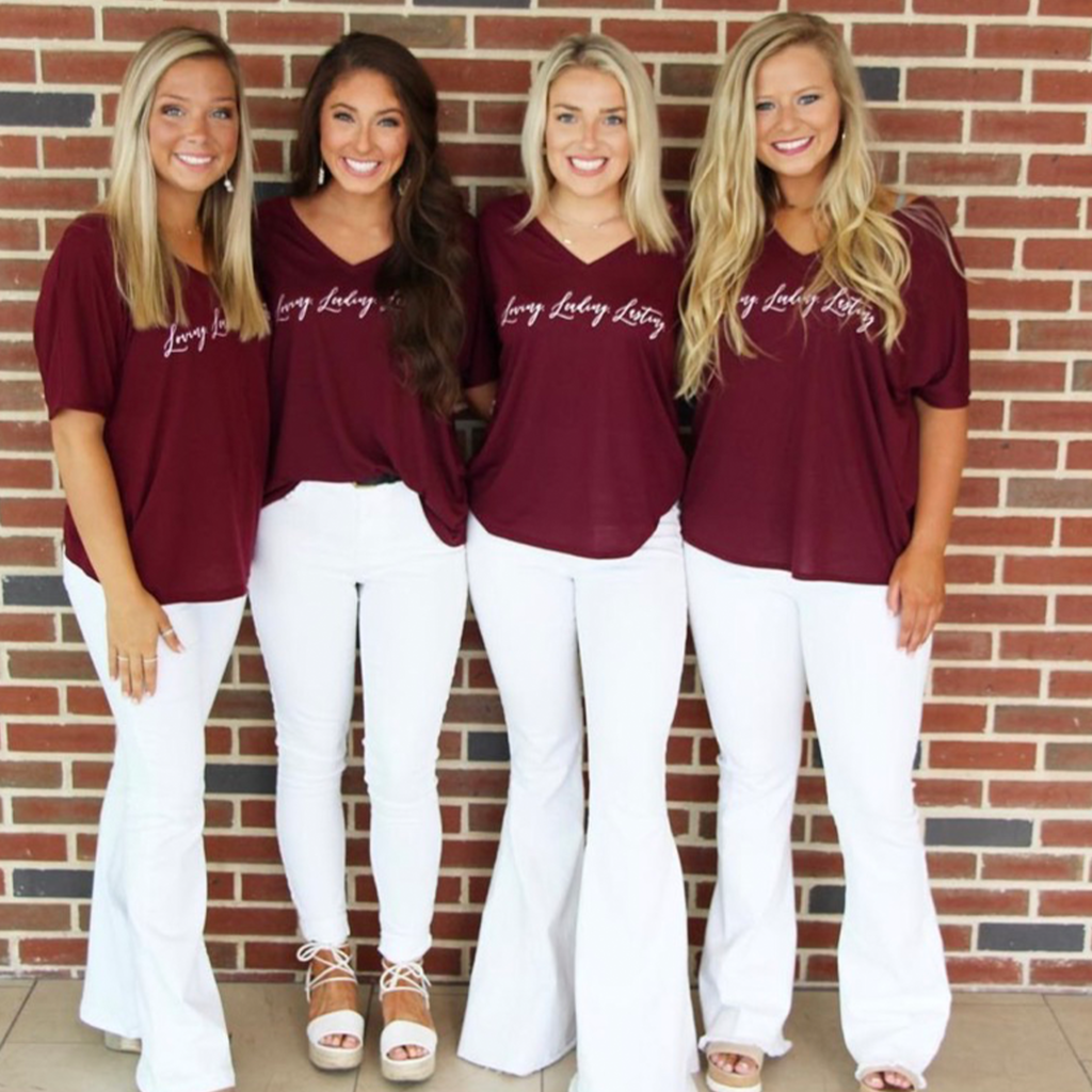 Four Alpha Gamma Delta Members wearing matching red shirts and white jeans.